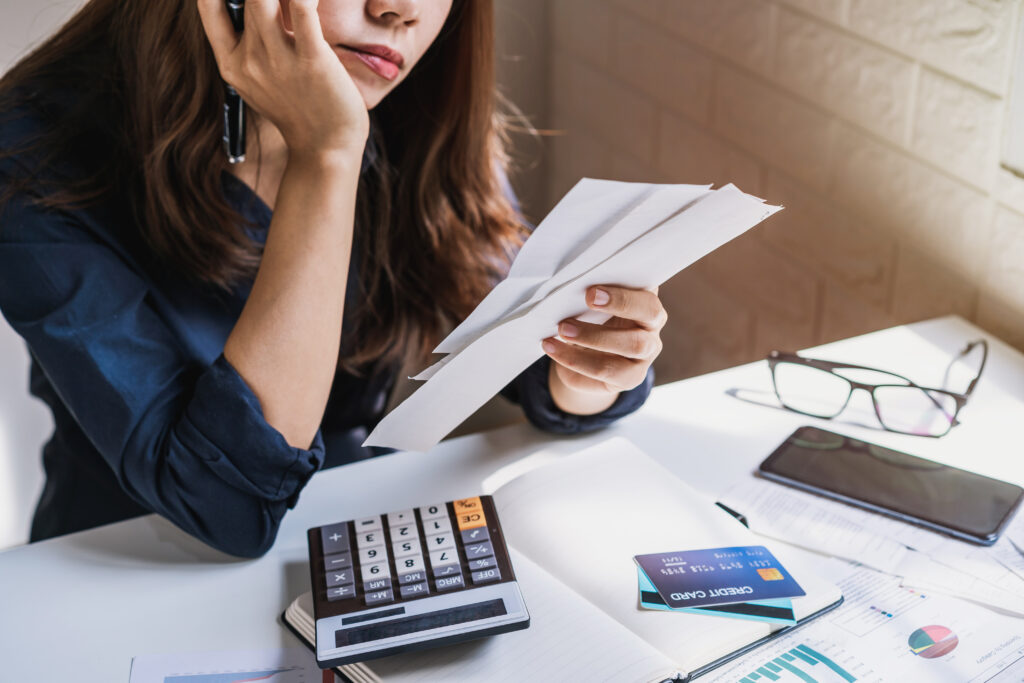 Negativação Indevida: entenda como funciona e como resolver - mulher segurando conta